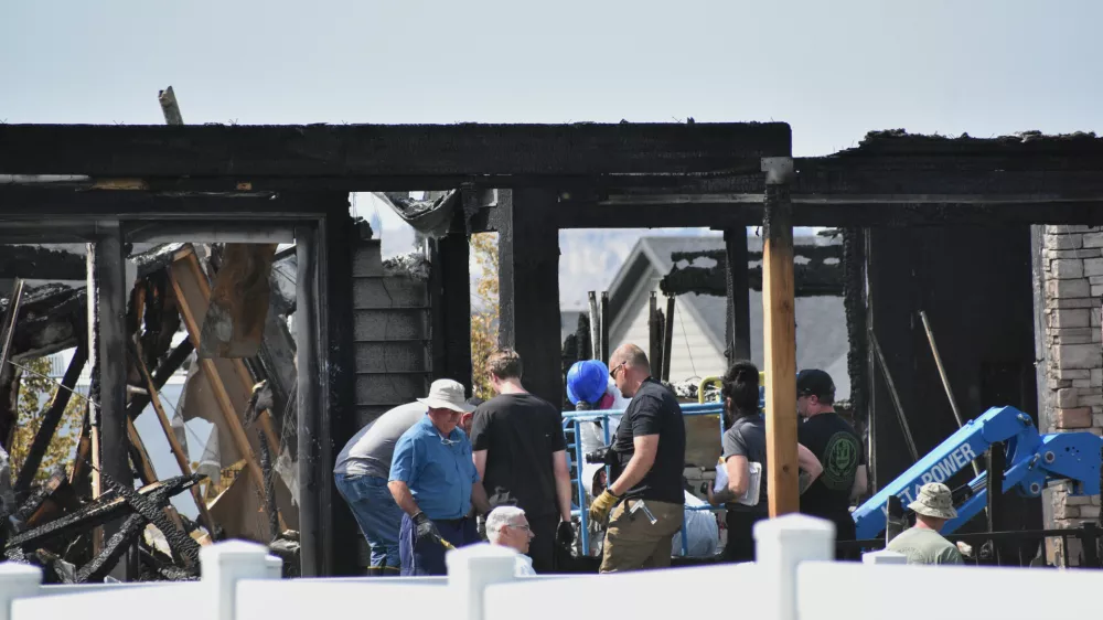 Investigators work at the scene Tuesday, Aug. 25, 2026, where a family was killed and the house burned in Billings, Mont. (AP Photo/Matthew Brown)