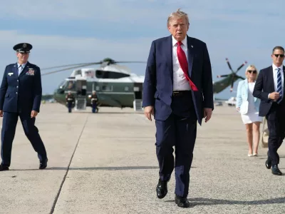 FILE - President Donald Trump, center, walks from Marine One to board Air Force One, Aug. 21, 2026, at Joint Base Andrews, Md., en route to South Carolina. (AP Photo/Jacquelyn Martin, File)