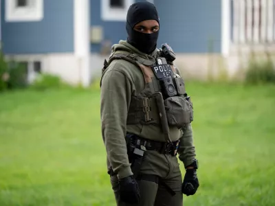 An Immigration and Customs Enforcement (ICE) agent stands by as an individual is detained outside a home in Danbury, Connecticut, U.S., August 27, 2026. REUTERS/Vincent Alban