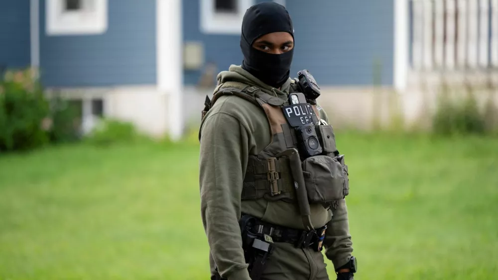 An Immigration and Customs Enforcement (ICE) agent stands by as an individual is detained outside a home in Danbury, Connecticut, U.S., August 27, 2026. REUTERS/Vincent Alban