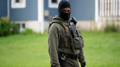 An Immigration and Customs Enforcement (ICE) agent stands by as an individual is detained outside a home in Danbury, Connecticut, U.S., August 27, 2026. REUTERS/Vincent Alban