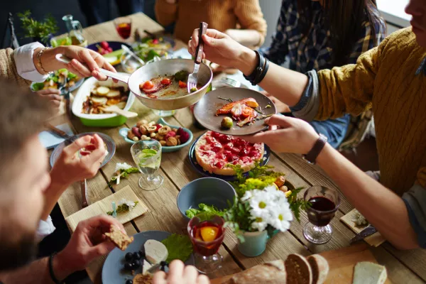 People sitting at dining table and eating / Foto: Shironosov