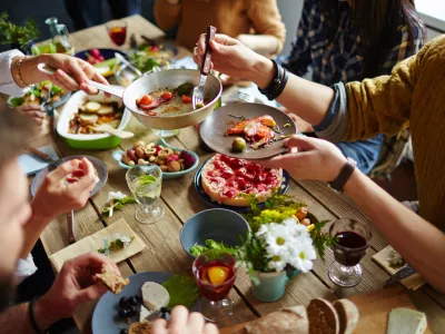 People sitting at dining table and eating / Foto: Shironosov
