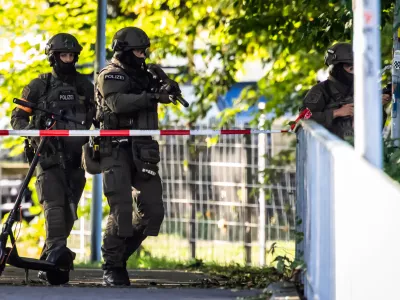 Armed police officers patrol near the Schachen horse racing track in Aarau following a shooting during a rave event near Aarau, Switzerland, Sunday, Aug. 30, 2026. (Michael Buholzer/Keystone via AP)