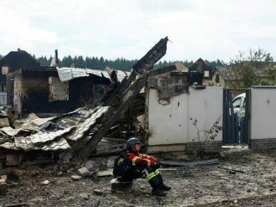 A rescuer rests next to a private house damaged by Russian drone strikes on Friday evening, amid Russia's attack on Ukraine, in Kyiv region, Ukraine August 30, 2026. REUTERS/Valentyn Ogirenko   TPX IMAGES OF THE DAY