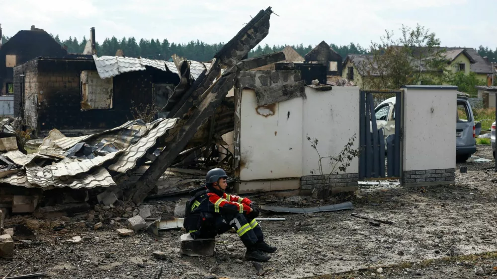 A rescuer rests next to a private house damaged by Russian drone strikes on Friday evening, amid Russia's attack on Ukraine, in Kyiv region, Ukraine August 30, 2026. REUTERS/Valentyn Ogirenko   TPX IMAGES OF THE DAY