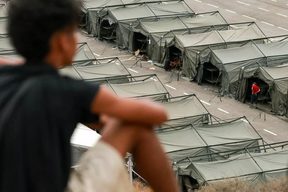 FILE PHOTO: A young unaccompanied migrant overlooks a shelter set up by the government after police cleared a makeshift beach camp in Spain's North African enclave of Ceuta following a mass crossing from Morocco, August 21, 2026. REUTERS/Violeta Santos Moura/File Photo