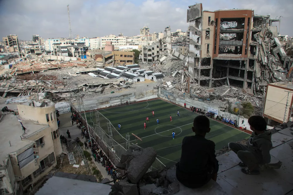 Otroci 26. aprila 2026 na stadionu Palestine v Gazi, obdanem z ru&scaron;evinami v zračnih napadih uničenih stavb, spremljajo tekmo malega nogometa med kluboma Al-Ahli in Al-Shati. Fotograf Ahmad Hasaballah je za posnetek, ki prikazuje poskus obuditve &scaron;portnega duha, prejel tretjo nagrado Visa d'or Online, ki jo podpira Douglas Kirkland Estate. F Ahmad Hasaballah / Foto: Ahmad Hasaballah