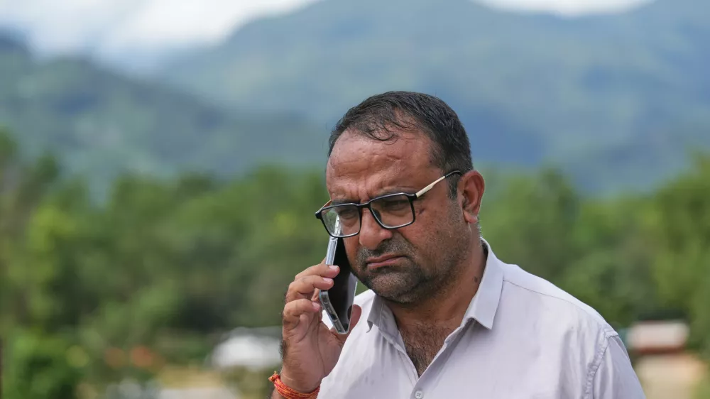 Rajendra Dawadi, a school teacher of Tribhuvan Trishuli Secondary School, talks on his mobile phone in Trishuli Valley in Nepal's Nuwakot district, Monday, Aug. 31, 2026. (AP Photo/Rajesh Kumar Singh)