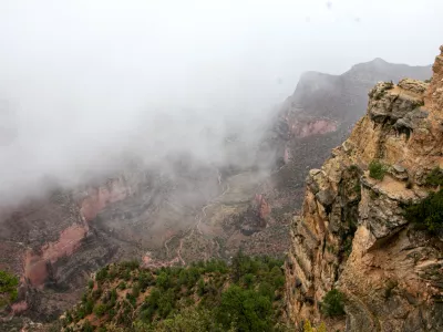 Mist and rain fall over Plateau Point in the Grand Canyon on Aug. 31, 2026, in Grand Canyon National Park, Ariz. (AP Photo/Josh Biggs)