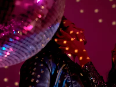 Drunk couple standing by disco ball, woman holding man face, passion and flirt