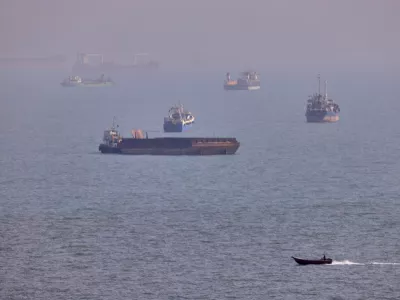 FILE - A small boat sails past cargo ships and other commercial vessels anchored in the Strait of Hormuz off Bandar Abbas, Iran, Wednesday, Aug. 5, 2026. (Amirhosein Khorgooi/ISNA via AP, File)