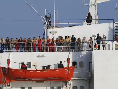 Handout file photo shows the crew of the Ukrainian merchant vessel, the MV Faina standing on the deck of the ship, anchored off the coast of Somalia, October 19, 2008 after a U.S. Navy request to check on their health and welfare Somali pirates released the MV Faina and its cargo of 33 Soviet-era T-72 tanks plus other weapons on February 5, 2009 following a ransom payment, a local man who helped negotiate the deal said. Picture taken October 19, 2008.  REUTERS/Specialist 2nd Class Jason R. Zalasky-U.S. Navy/Handout/Files   (UNITED STATES)