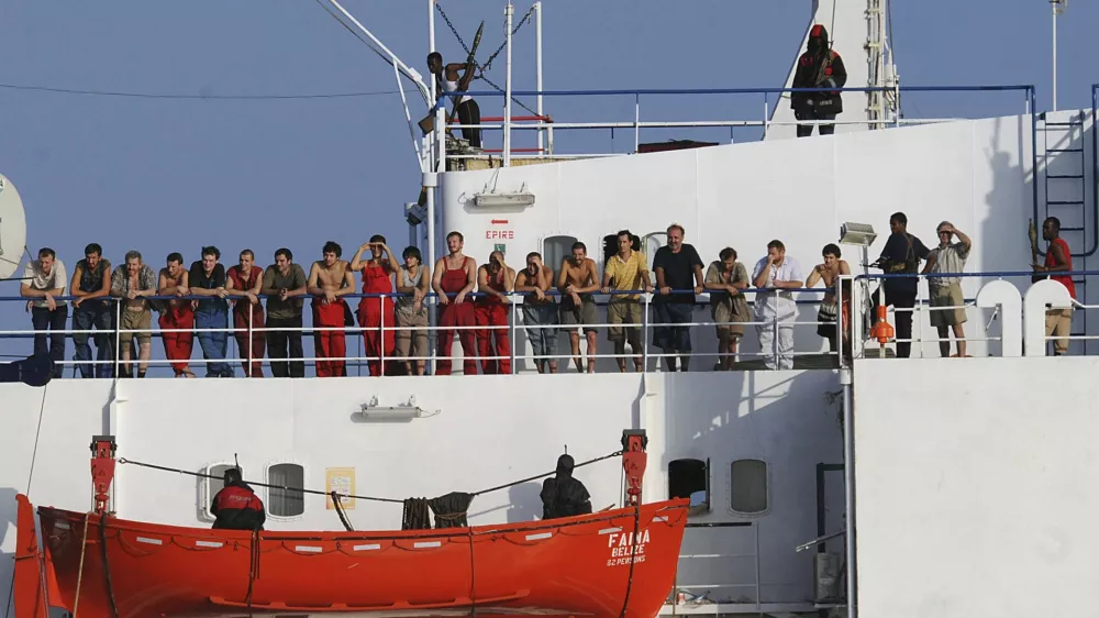Handout file photo shows the crew of the Ukrainian merchant vessel, the MV Faina standing on the deck of the ship, anchored off the coast of Somalia, October 19, 2008 after a U.S. Navy request to check on their health and welfare Somali pirates released the MV Faina and its cargo of 33 Soviet-era T-72 tanks plus other weapons on February 5, 2009 following a ransom payment, a local man who helped negotiate the deal said. Picture taken October 19, 2008.  REUTERS/Specialist 2nd Class Jason R. Zalasky-U.S. Navy/Handout/Files   (UNITED STATES)