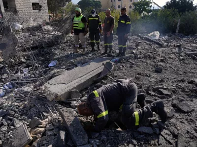 Rescue workers search for victims under the rubble of a building destroyed in an Israeli airstrike in the southern village of Kfar Rumman, Lebanon, Monday, Sept. 7, 2026. (AP Photo/Mohammed Zaatari)