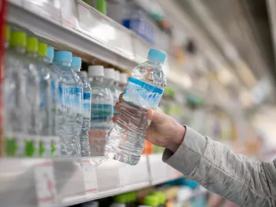 Shopper's hands buying bottled water