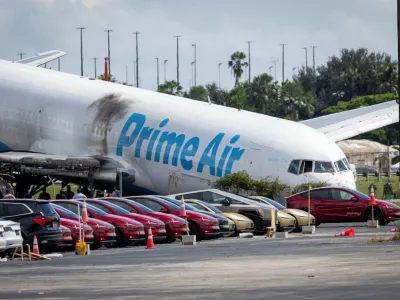 Tesla cars are parked in a lot next to where a crashed Amazon Prime Air cargo plane came to rest, where airport officials said it overran a runway at Miami International Airport, in Miami, Florida, U.S., September 7, 2026. REUTERS/Marco Bello