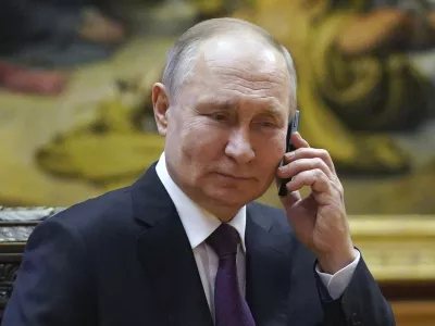 Russian President Vladimir Putin talks on the phone to eight-year-old Alexandra Titarenko from Zaporizhzhia region, a participant in the Fir Tree of Wishes charity campaign at the State Russian Museum in St. Petersburg, Russia, Tuesday, Dec. 27, 2022. (Alexey Danichev, Sputnik, Kremlin Pool Photo via AP)
