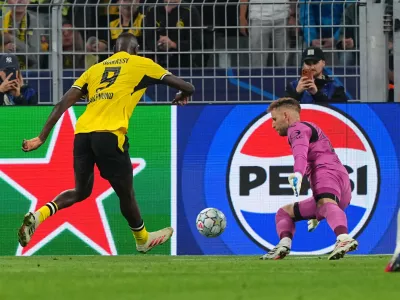 Dortmund's Serhou Guirassy, left, misses to score past Villarreal's goalkeeper Peter Gulacsi during the Champions League opening phase soccer match between Borussia Dortmund and Villarreal in Dortmund, Germany, Tuesday, Sept. 8, 2026. (AP Photo/Martin Meissner)