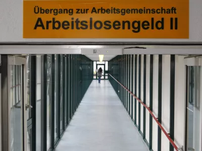 ARCHIV - Eine Frau laeuft am 29. Januar 2009 durch die Agentur fuer Arbeit in Ludwigsburg. Zu fuenf Jahre Hartz IV gibt das Institut fuer Arbeitsmarkt- und Berufsforschung in Berlin am Dienstag, 15. Dezember 2009 eine Pressekonferenz. (AP Photo/ Thomas Kienzle,file) --- FILE - A woman walks through the labor office in Ludwigsburg, Germany, Jan. 29, 2009. The sign reads: "Crossover to team unemployment benefit II". (AP Photo/Thomas Kienzle,file)