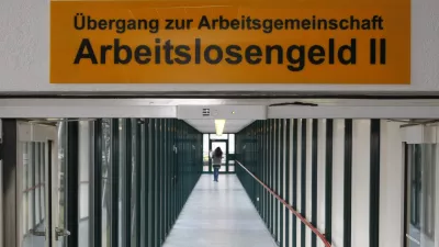 ARCHIV - Eine Frau laeuft am 29. Januar 2009 durch die Agentur fuer Arbeit in Ludwigsburg. Zu fuenf Jahre Hartz IV gibt das Institut fuer Arbeitsmarkt- und Berufsforschung in Berlin am Dienstag, 15. Dezember 2009 eine Pressekonferenz. (AP Photo/ Thomas Kienzle,file) --- FILE - A woman walks through the labor office in Ludwigsburg, Germany, Jan. 29, 2009. The sign reads: "Crossover to team unemployment benefit II". (AP Photo/Thomas Kienzle,file)