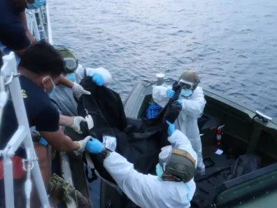 In this handout provided by the Philippine Coast Guard, rescuers transfer the remains of victims of the recent fire on the MV June Aster ferry on Friday Sept. 11, 2026 off Coron, Palawan province, western Philippines. (Philippine Coast Guard via AP)
