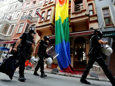 FILE PHOTO: Riot police, with a rainbow flag in the background, chase LGBT rights activists as they try to gather for a pride parade, which was banned by the governorship, in Istanbul, Turkey, June 26, 2016. REUTERS/Murad Sezer/File Photo