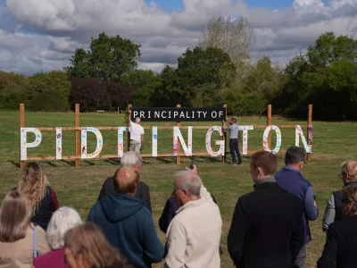 Local residents unveil a "Principality of Piddington" sign in the village of Piddington, Oxfordshire, England, Wednesday, Sept. 16, 2026, after they voted overwhelmingly to become an independent state in a symbolic "referendum". (Joe Giddens/PA via AP)