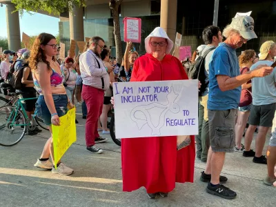 Sara Ellis, 37, wearing a Handmaid's Tale costume, attends a protest in response to the U.S. Supreme Court ruling overturning Roe v. Wade abortion rights decision, in Houston, Texas, U.S. June 24, 2022. Picture taken June 24, 2022. REUTERS/Sabrina Valle
