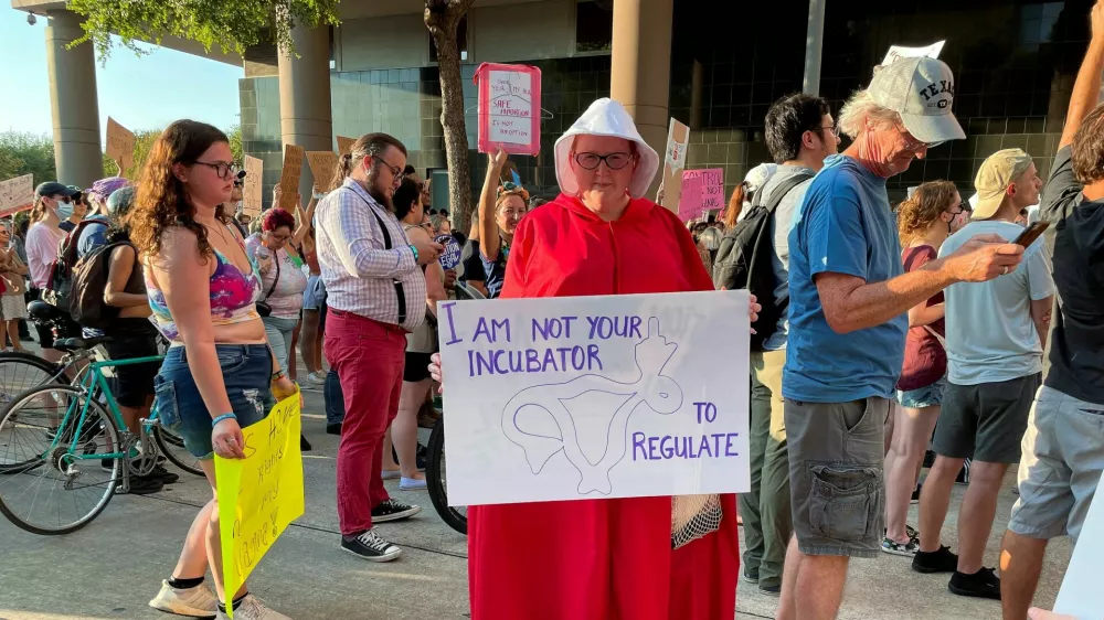 Sara Ellis, 37, wearing a Handmaid's Tale costume, attends a protest in response to the U.S. Supreme Court ruling overturning Roe v. Wade abortion rights decision, in Houston, Texas, U.S. June 24, 2022. Picture taken June 24, 2022. REUTERS/Sabrina Valle