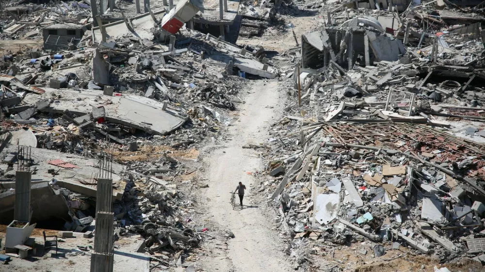 A man pushes a bycicle along as he walks amid building rubble in the devastated area around Gaza's Al-Shifa hospital on April 3, 2024, amid the ongoing conflict between Israel and the Palestinian Hamas militant group.,Image: 862136714, License: Rights-managed, Restrictions:, Model Release: no 
