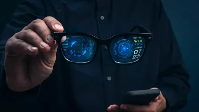 Smart glasses with augmented reality interface showing digital data and futuristic UI holding in businessman hands. Concept of wearable technology, AR innovation, and next-generation smart devices. / Foto: Techa Tungateja