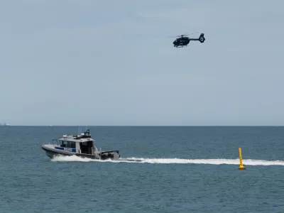 A police boat and and helicopter patrol the area at Sorrento Beach, in Perth, Australia, Friday, Sept. 18, 2026, after a suspected fatal shark attack. (Andrew O'Connor/Australian Broadcasting Corp via AP)