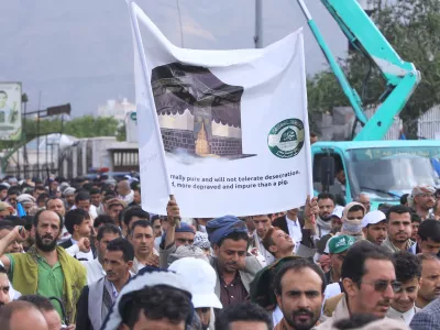 Supporters of Yemen's Houthi rebels raise a banner during a rally in support of the group and to protest Saudi Arabia's accusation that the Houthis targeted Islam's holiest site of Mecca, in Sanaa, Yemen, Friday, Sept. 18, 2026. (AP Photo/Osamah Abdulrahman)