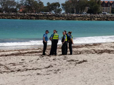 Police stand on Sorrento Beach, in Perth, Australia, Friday, Sept. 18, 2026, after a suspected fatal shark attack. (Andrew O'Connor/Australian Broadcasting Corp via AP)