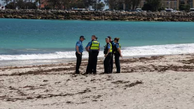 Police stand on Sorrento Beach, in Perth, Australia, Friday, Sept. 18, 2026, after a suspected fatal shark attack. (Andrew O'Connor/Australian Broadcasting Corp via AP)