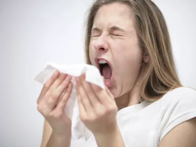 young woman sneezing