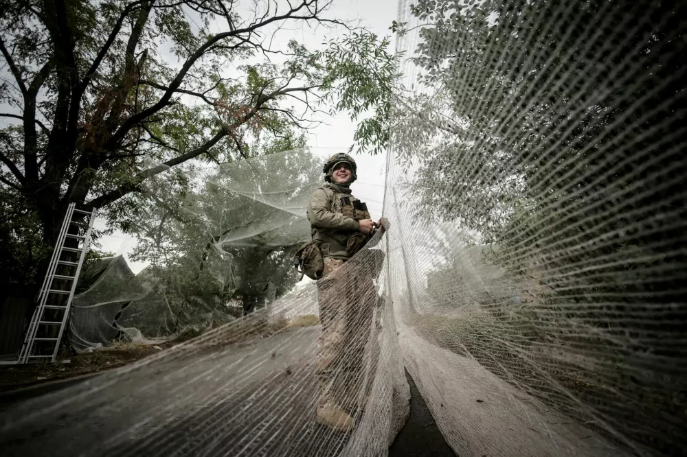 FILE PHOTO: A serviceman of the 24th Mechanized Brigade, named after King Danylo, of the Ukrainian Armed Forces installs anti-drone nets over a road, amid Russia's attack on Ukraine, in the frontline town of Kostiantynivka in Donetsk region, Ukraine September 19, 2025. Oleg Petrasiuk/Press Service of the 24th King Danylo Separate Mechanized Brigade of the Ukrainian Armed Forces/Handout via REUTERS ATTENTION EDITORS - THIS IMAGE HAS BEEN SUPPLIED BY A THIRD PARTY./File Photo