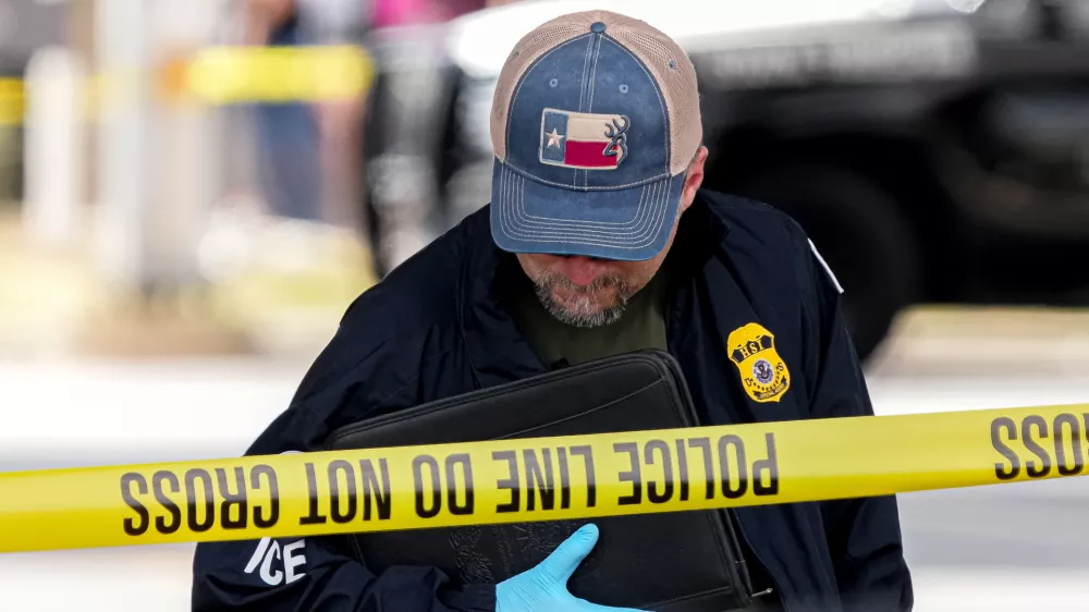 An Immigration and Customs Enforcement officer walks the scene where a man was shot in his vehicle by an ICE officer, Sunday, Sept. 20, 2026, in Austin, Texas. (Aaron E. Martinez /Austin American-Statesman via AP)