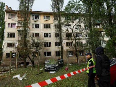 A police officer and residents stand in front of an apartment building which was hit by a Russian drone strike, amid Russia's attack on Ukraine, in Kyiv, Ukraine September 22, 2026. REUTERS/Valentyn Ogirenko