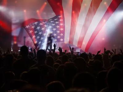 Crowd of people celebrating Independence Day. United States of America USA flag with fireworks background for 4th of July.