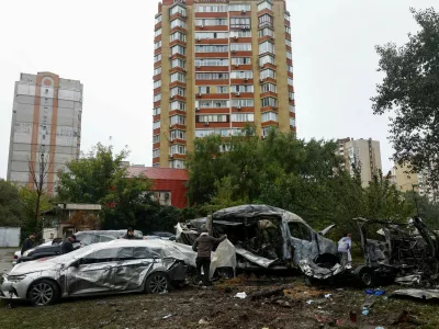 Residents use plastic film to cover their damaged cars hit by a Russian drone strike at a parking lot in a residential area, amid Russia's attack on Ukraine, in Kyiv, Ukraine September 24, 2026. REUTERS/Valentyn Ogirenko