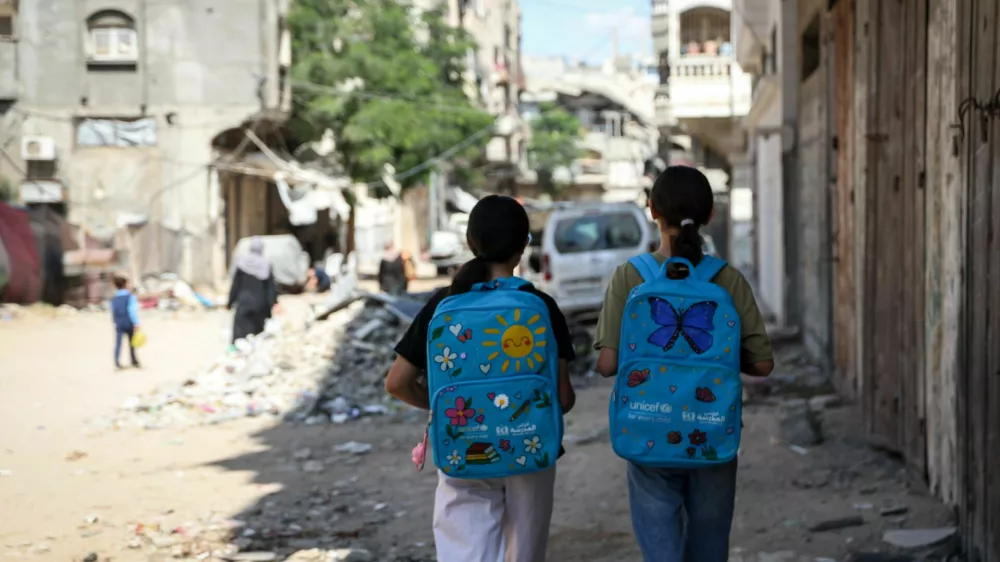 GAZA, PALESTINE - SEPTEMBER 26: Palestinian students walk through the damaged streets of the Sheikh Radwan neighborhood in northern Gaza carrying UNICEF school bags decorated with colorful designs by artist Sara Zakkut, on September 26, 2026 in Gaza, Palestine. The 21-year-old artist decorates school bags distributed by UNICEF to lift the spirits of children living amid a severe humanitarian crisis and shortages of basic necessities under the Israeli blockade. Zakkut continues her work inside a heavily damaged building, seeking to support students struggling to continue their education despite ongoing Israeli attacks. Abdalhkem Abu Riash / AnadoluNo Use USA No use UK No use Canada No use France No use Japan No use Italy No use Australia No use Spain No use Belgium No use Korea No use South Africa No use Hong Kong No use New Zealand No use Turkey / Foto: Abdalhkem Abu Riash