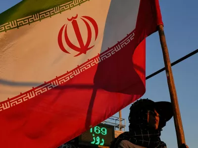 A woman holds an Iranian flag as part of a pro-government campaign in downtown Tehran, Tuesday, Sept. 15, 2026. (AP Photo/Vahid Salemi)