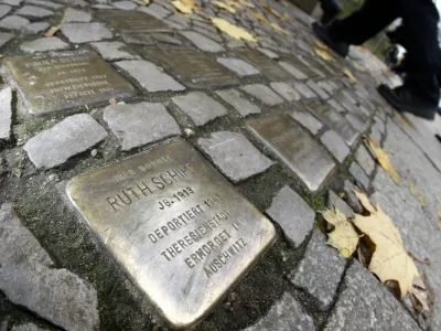 Pedestrians walk past so-called 'Stolpersteine' (stumbling blocks), memorial pavement plaques commemorating German Jews who died in the concentration camps of Auschwitz and Theresienstadt, in Berlin's Wilmersdorf district November 7, 2008. German artist Gunter Demnig has embedded into pavements across Germany, Austria, Hungary and the Netherlands where Jews were living during the Nazi era.    REUTERS/Fabrizio Bensch (GERMANY) - BM2E4B715CC01