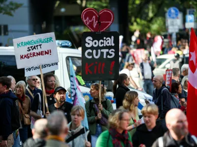 People hold signs as they attend a protest of the German Trade Union Confederation (DGB) against social cuts, in Berlin, Germany, September 26, 2026. REUTERS/Maryam Majd
