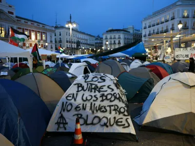 A writing on a tent reads "Vultures belong in the forests, not in our buildings", after demonstrators and supporters set up a camp at Puerta del Sol square in protest against Spain's housing crisis after the forceful eviction of an 87-year-old woman from her apartment in Madrid, Spain, September 28, 2026. REUTERS/Juan Medina
