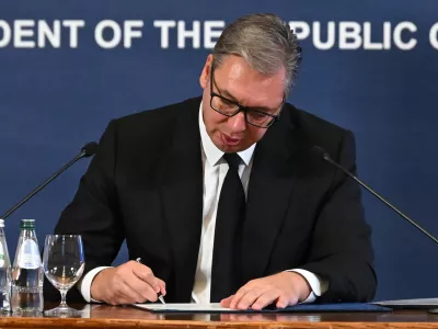 This photo released by Serbia's presidential press office shows Serbian President Aleksandar Vucic signing his resignation as President of the Republic, in order to run for prime minister, in Belgrade, Serbia, Sunday, Sept. 27, 2026. (Serbian presidential press office via AP)