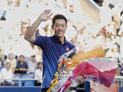 Japan's Kei Nishikori waves as he leaves the court following his first round loss to Frances Tiafoe of the U.S., at the Japan Open tennis championship in Tokyo, Thursday, Oct. 1, 2026. (Daiki Katagiri/Kyodo News via AP)