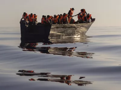 FILE - Migrants with life jackets provided by volunteers of the Ocean Viking, a migrant search and rescue ship run by NGOs SOS Mediterranee and the International Federation of Red Cross (IFCR), sail in a wooden boat as they are being rescued some 26 nautical miles&nbsp;south of the Italian Lampedusa island in the Mediterranean sea,&nbsp;on Aug. 27,&nbsp;2022. The U.N. human rights chief is appealing to governments to do more to help migrants and asylum-seekers after a "steep increase" in the numbers making risky attempts to cross the central Mediterranean to Europe. (AP Photo/Jeremias Gonzalez, File)